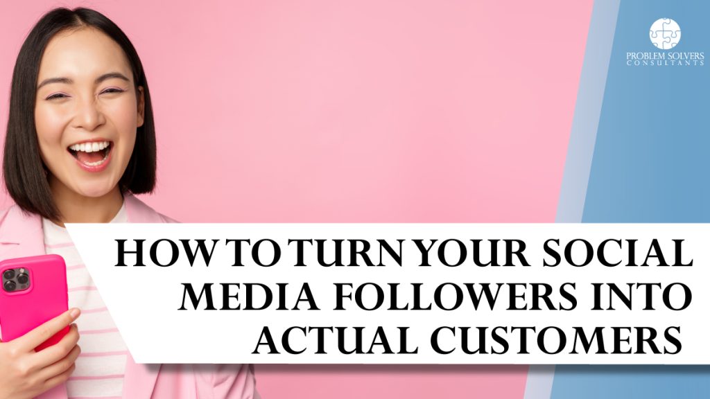 Smiling woman in a pink blazer holds a phone, standing next to a banner that reads, “How to turn your social media followers into actual customers.”.